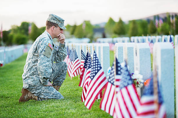 Soldier kneeling at grave American soldier in uniform on memorial day.  memorial day stock pictures, royalty-free photos & images
