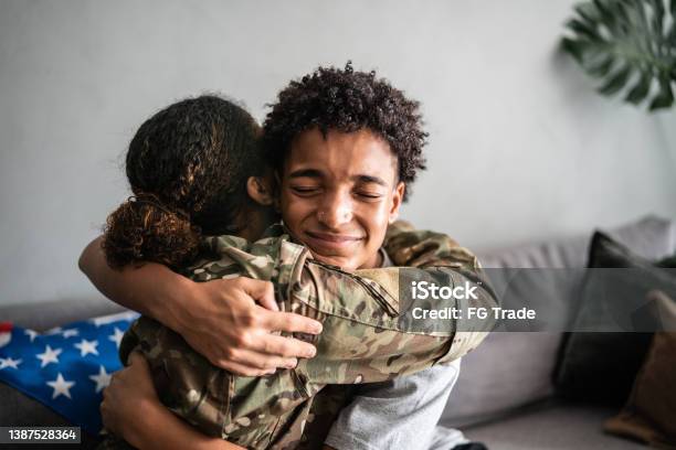 Soldier mother and son hugging each other at home