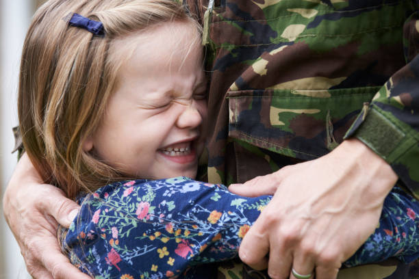 Soldier On Leave Being Hugged By Daughter  soldiers returning home stock pictures, royalty-free photos & images