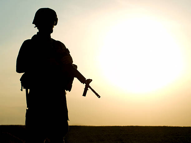 US soldier Silhouette of US soldier with rifle against a sunset us military stock pictures, royalty-free photos & images