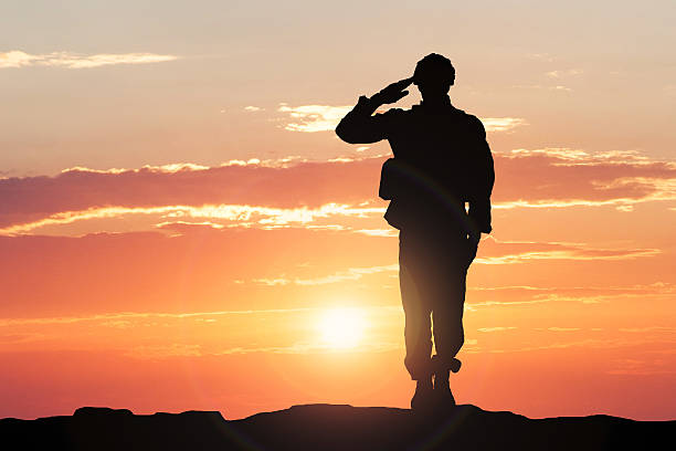 Soldier Saluting During Sunset Silhouette Of A Soldier Saluting During Sunset army soldier stock pictures, royalty-free photos & images