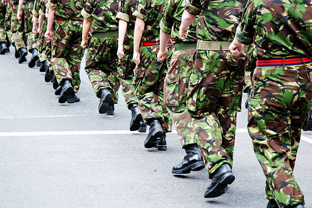 soldiers marching in line - army stockfoto's en -beelden