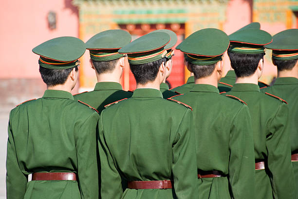 Soldiers Unrecognizable group of soldiers standing in line and seen from behind. Wearing uniforms including caps. The soldiers belong to the Chinese armed forces. communism stock pictures, royalty-free photos & images