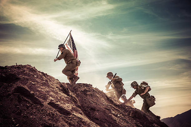WWII Soldiers Taking a Hill Vintage photograph of authentic World War II army soldier in battle reenactment. conquering adversity photos stock pictures, royalty-free photos & images