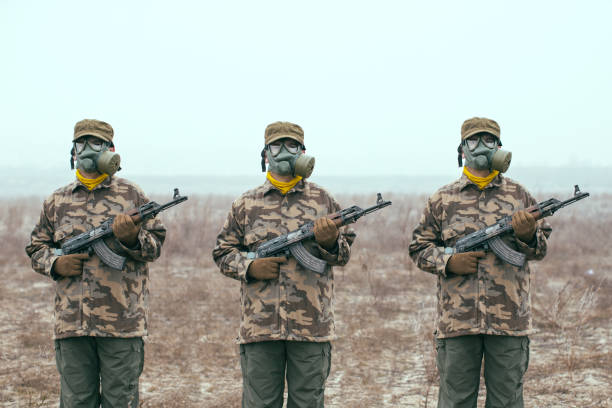 Soldiers with gas mask and automatic guns standing ready soldiers with gas mask and automatic guns standing ready militia stock pictures, royalty-free photos & images