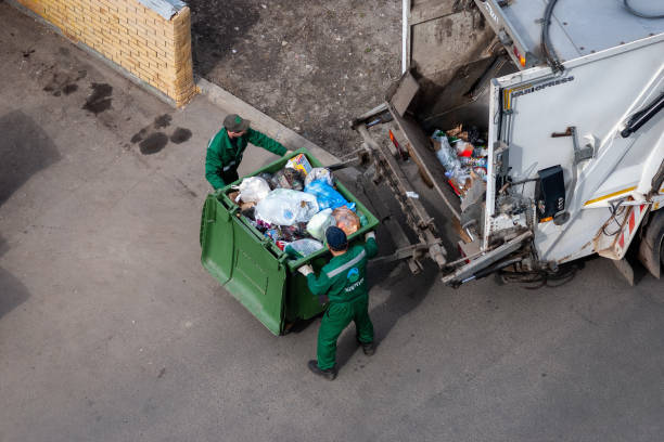 Solid waste collection workers loading garbage truck stock photo