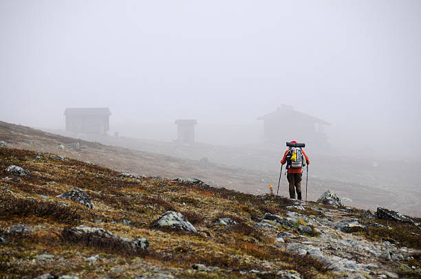 Solitary hiker in Lapland heads toward mist-shrouded wilderness huts KAsivarsi Wilderness Area, Finland - July 1, 2012: A Solitary hiker in Lapland heads toward mist-shrouded wilderness huts. KAsivarsi Wilderness Area is one of Europe's last wilderness zones, attracting many hikers. kilpisjarvi lake stock pictures, royalty-free photos & images