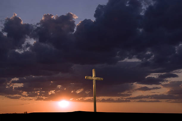 croix vieilli solitaire au coucher du soleil - good friday photos et images de collection