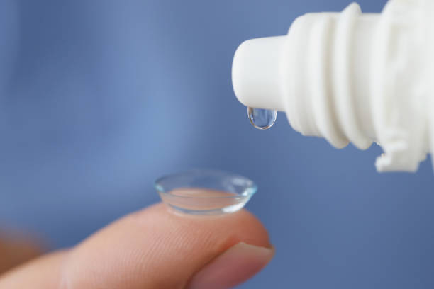 Solution is dripped onto soft contact lens closeup stock photo