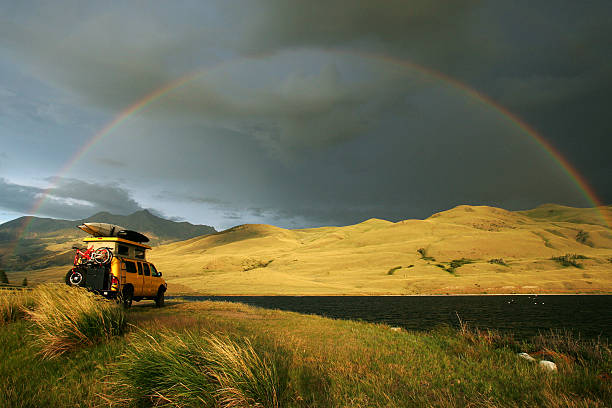 Some camping in a yellow truck with belongings on top stock photo