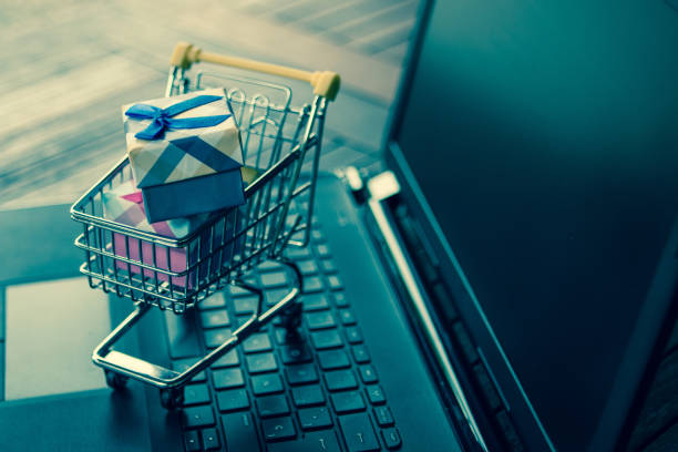 Some gifts inside a small trolley on a computer. Shopping online and sale concept. stock photo