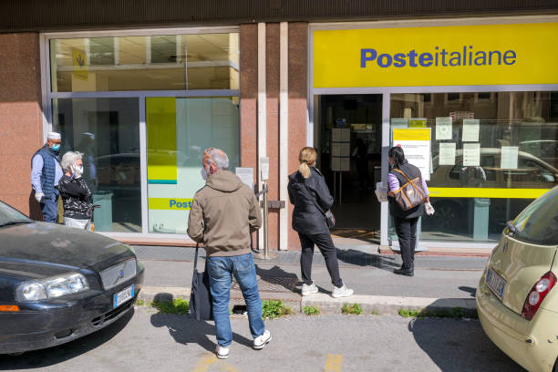 Some people wait in line to enter a post office in Rome during the Covid-19 emergency stock photo