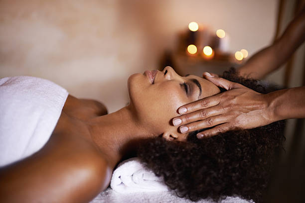 Some well needed me time Shot of a beautiful young woman getting a head massage at a spa massage stock pictures, royalty-free photos & images