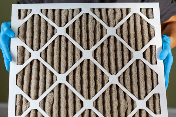 someone holding a very dirty clogged air conditioner furnace filter stock photo