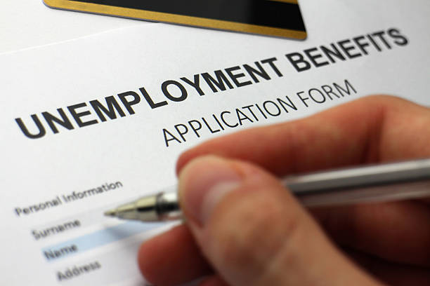Someone 'signing on' Someone completing an unemployment benefits form. unemployment photos stock pictures, royalty-free photos & images