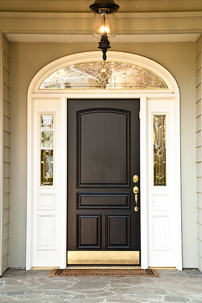 Image is of a front doorway to a home. It shows a very dark brown...