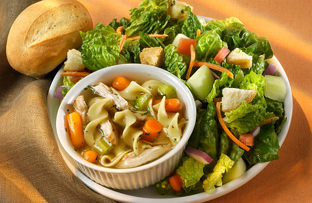 Soup and Salad Cup of chunky chicken noodle soup and fresh green salad.  Healthy Lunch or dinner.Shot with a Nikon. burwellphotography stock pictures, royalty-free photos & images