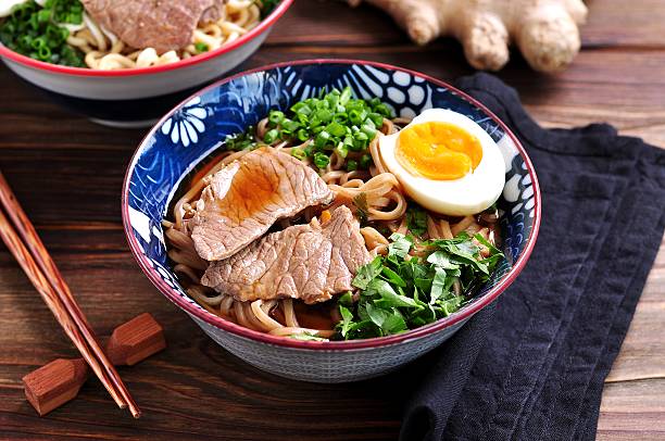 Soup with soba and ramen noodles, beef, ginger, green onions stock photo