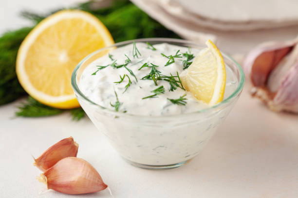 Sour cream sauce with dill and garlic in a bowl on the table. Organic food stock photo