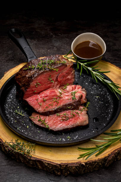 Sous-vide grilled beef steak with herbs on cast-iron skillet stock photo