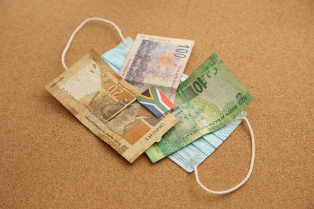 una bandera sudafricana y dinero en una máscara facial. - south africa covid fotografías e imágenes de stock