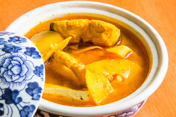 Southern Thai Spicy Sour Yellow Curry with Sea Bass and Coconut Shoots, Sour soup made of Tamarind Paste or Turmeric. stock photo