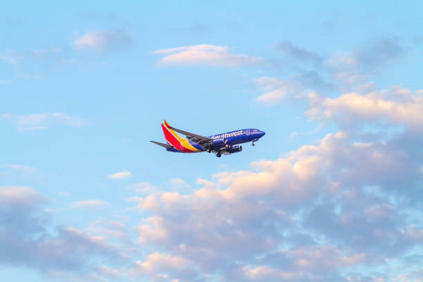 A Southwest Airlines airplane flying over the sky of Santa Ana, CA stock photo