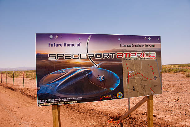 Spaceport America Site in New Mexico "Las Cruces, New Mexico, USA - June 10, 2011: Construction of the basic infrastructure of Spaceport America in southern New Mexico was nearing completion in June 2011. The new commercial facility is operated by the New Mexico Spaceport America Authority, based in Las Cruces. Testing of suborbital space vehicles already has taken place at the remote site 45 miles north of Las Cruces. The showcase building at Spaceport America will be a unique, low profile hangar (now under construction) that itself is shaped like a spacecraft as depicted in this sign. The hangar has been leased for 20 years to Virgin Galactic owned by British billionaire Richard Branson, who already has a waiting list of several hundred future astronauts willing to pay $200,000 each to be launched into suborbit from this site. Launches of vehicles carrying space tourists are expected to begin in the near future." spaceport stock pictures, royalty-free photos & images