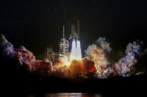 Spaceship launch at night, landscape with colorful smoke clouds and galaxy background. The elements of this image furnished by NASA.