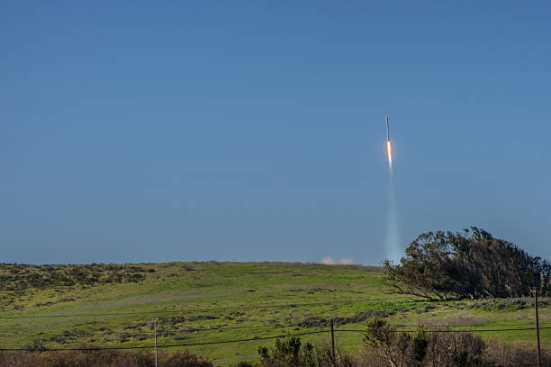 Spacex Falcon 9 one second after take off. Lompoc, California, USA - January 14, 2017: Vandenberg Air Force Base where Spacex launched this morning a Falcon 9 rocket transporting ten Iridium satellites. The rocket in the blue air one second after takeoff. Green grass. Fire and smoke. iridium stock pictures, royalty-free photos & images