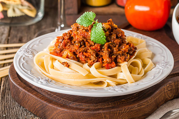 Spaghetti Bolognese on white plate Spaghetti Bolognese on white plate, wooden background tagliatelle stock pictures, royalty-free photos & images