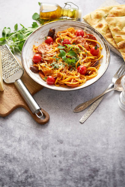 Spaghetti with spicy sausages, tomato sauce, parmesan cheese stock photo