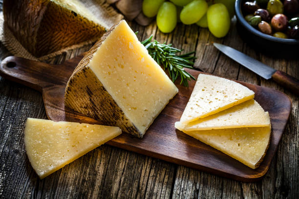 spaans eten: manchego kaas op rustieke houten tafel - manchego stockfoto's en -beelden