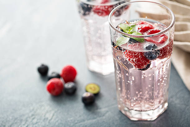sparkling water with raspberries and blueberries - soda stok fotoğraflar ve resimler