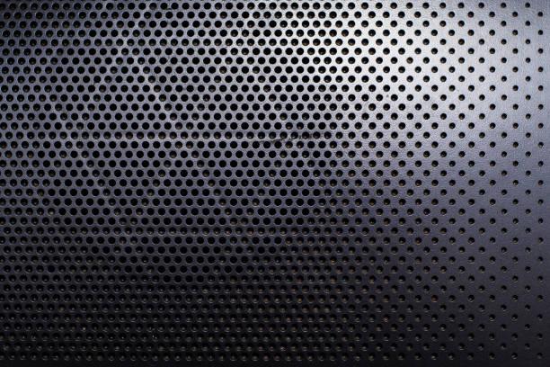 Speaker holes texture. Drawing of air vents in the black plastic surface view up. stock photo