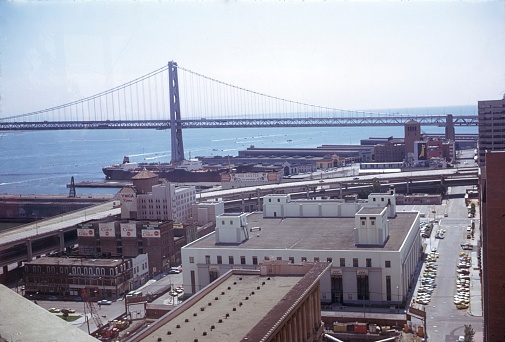 The East Cut, San Francisco, California, USA, 1974. Spear Street and Oakland Bay Bridge in San Francisco. Also: Buildings, Cars, Pier 26-28, City Motorway, Cargo Ship, Wharton Building and Billboards.