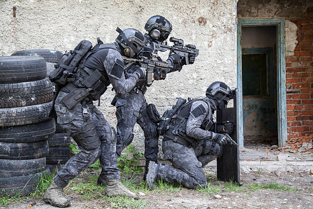 Spec ops police officer SWAT Spec ops police officers SWAT in black uniform in action special forces stock pictures, royalty-free photos & images
