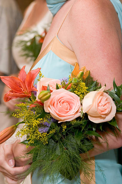 A woman in formal attire holding a bouquet of flowers.
