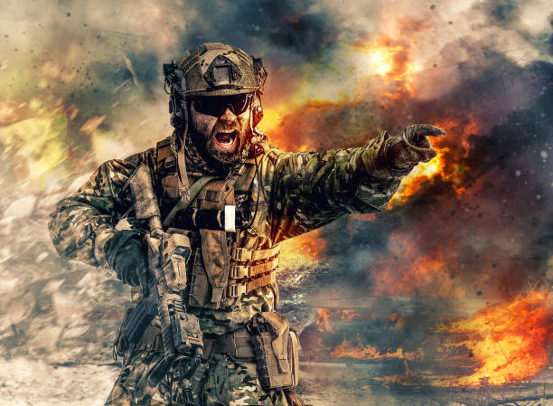 special forces in action Bearded soldier of special forces in action pointing target and giving attack direction. Burnt ruins, Heavy explosions, gunfire and smoke billowing on background special forces stock pictures, royalty-free photos & images