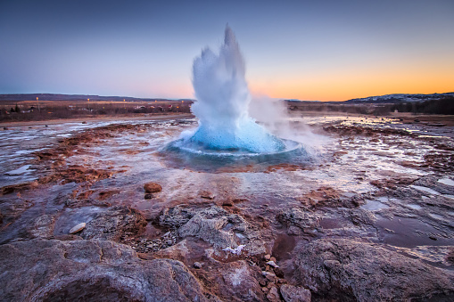 Spectacular well timmed capture of geotermal eruption at Gullfoss Geysir, The Great Geysir or Stokkur Geyser the most energetic spouting spring up to 40 meters in Iceland after sunset in twilight. Shot on Canon EOS 60D, 11mm wide lens, f4, ISO 800.