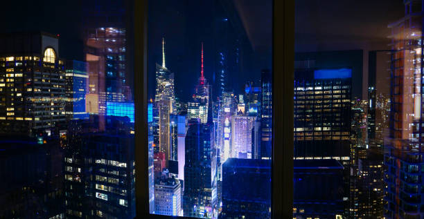 CLOSE UP: Spectacular view of Times Square at night from a luxury hotel room. stock photo