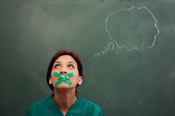 Speech bubble on blackboard, woman's moth closed with adhesive tape Blank speech bubble on blackboard and woman's moth closed with adhesive tape human mouth gag adhesive tape women stock pictures, royalty-free photos & images