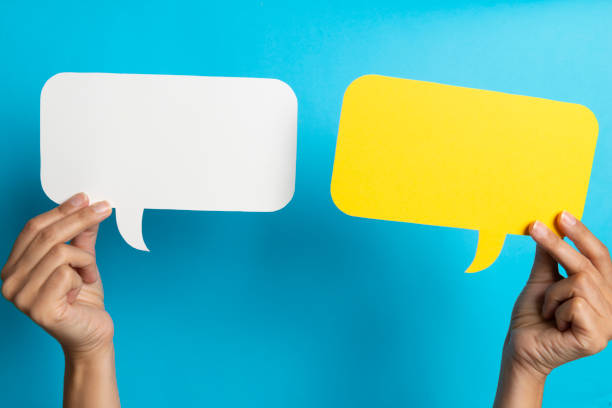 Speech Bubbles Two hands are holding two speech bubbles which are white and yellow. bubble photos stock pictures, royalty-free photos & images