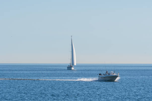 lancha ultrapassando um veleiro na água do mar báltico - speed boat versus sail boat - fotografias e filmes do acervo