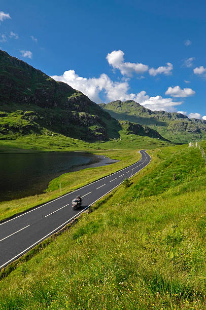 Speeding motorbike on mountain road in Scotland stock photo