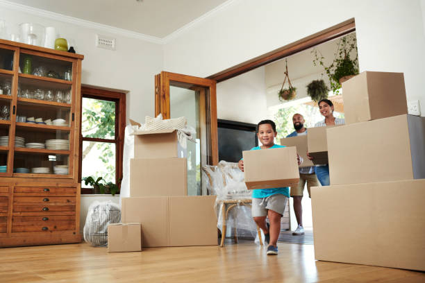 Spending time with family is worth every second Shot of young family of three carrying moving boxes into their new home moving house photos stock pictures, royalty-free photos & images