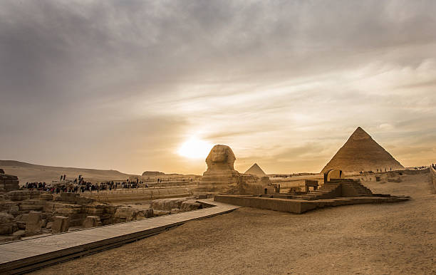 Sphinx and Pyramids Sunset of the Pyramids and the Sphinx in Cairo sphinx stock pictures, royalty-free photos & images