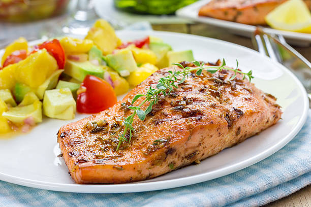 Spice grilled salmon with mango-avocado salsa on a white plate stock photo