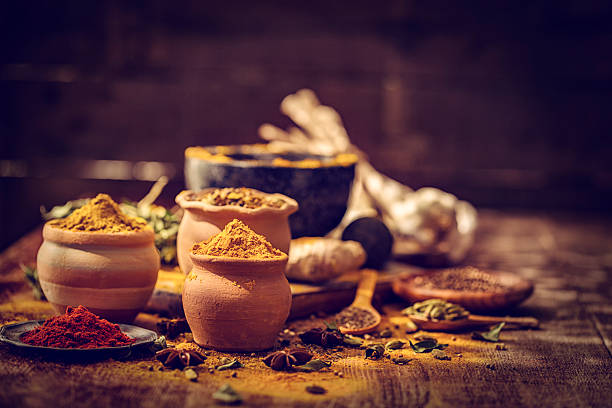 Spices and Herbs on Wooden Background Variation of Spices and Herbs like chili peppers, parsley, rosemary, peppercorns, cayenne pepper, tumeric, cumin, garlic and ginger on wooden background cumin stock pictures, royalty-free photos & images