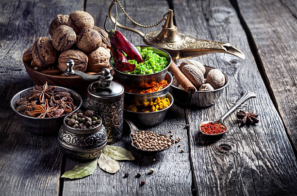 Spices and nuts at wooden table Spices, pepper grinder, spoon with seeds at grey wooden background culture of india photos stock pictures, royalty-free photos & images